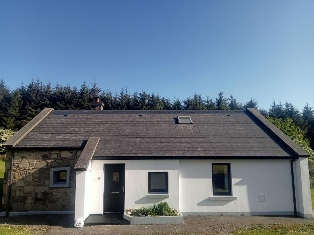 a white house with a black roof at Kearneys Cottage, Dugort, Achill Island, County Mayo - 3 Bedroom Sleeps 6 in Bellanasally