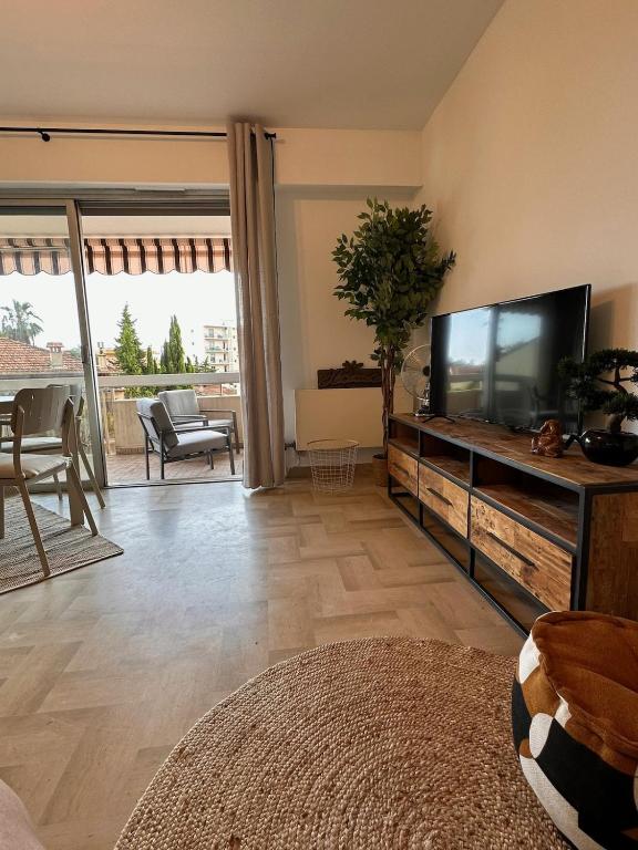 un salon avec une grande télévision à écran plat dans l'établissement A 200m des plages grand studio ouvrant sur très large terrasse, à Juan-les-Pins