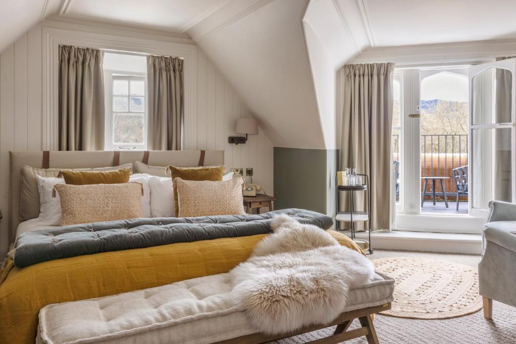 a bedroom with a large bed with a large window at Pine Trees Hotel Pitlochry in Pitlochry