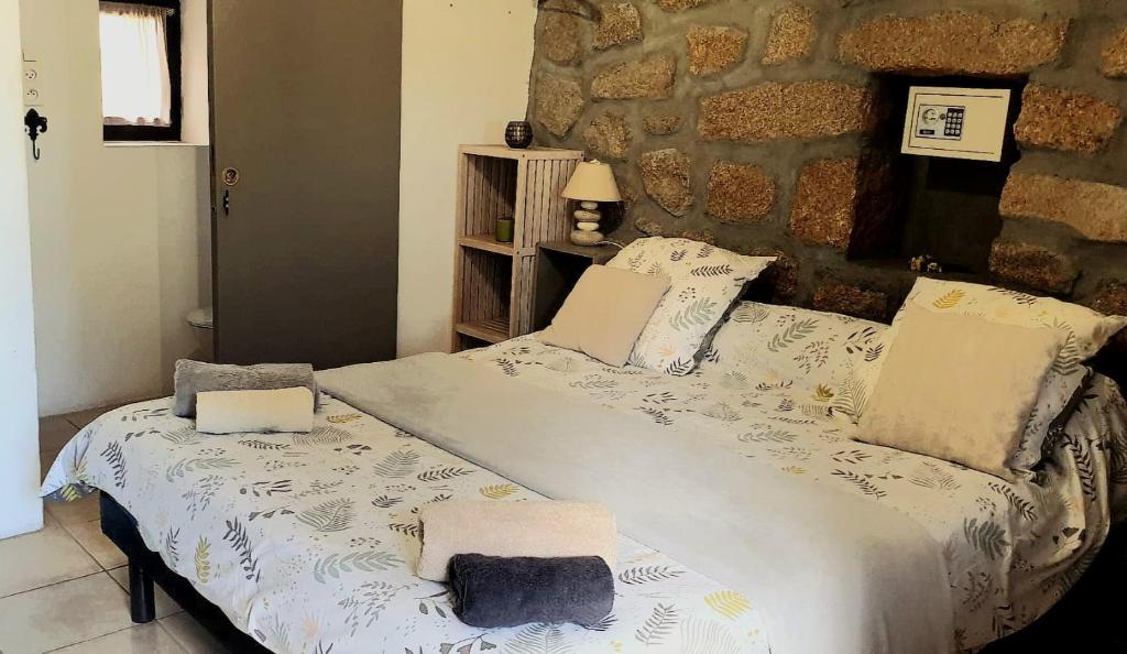 sypialnia z łóżkiem i kamienną ścianą w obiekcie Chez Robert et Sylvie w mieście Pianottoli-Caldarello