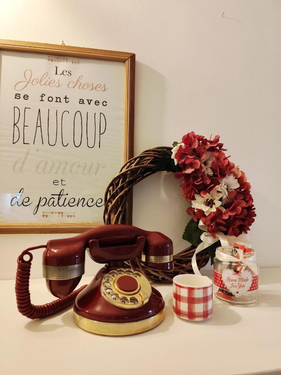 a telephone on a table with a wreath and a picture at Le Grenier Apartment in Turin