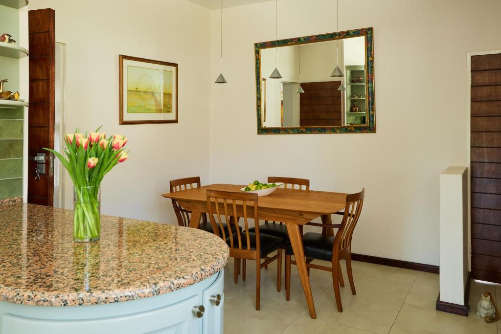 a dining room with a table and a vase of flowers at 42 On Strathmore in Cape Town