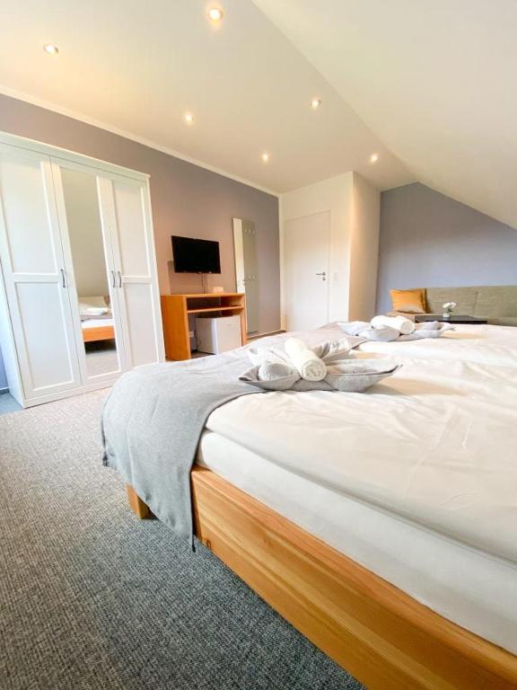 a large bedroom with a large bed with white sheets at Roschi's Gästehaus in Gudow