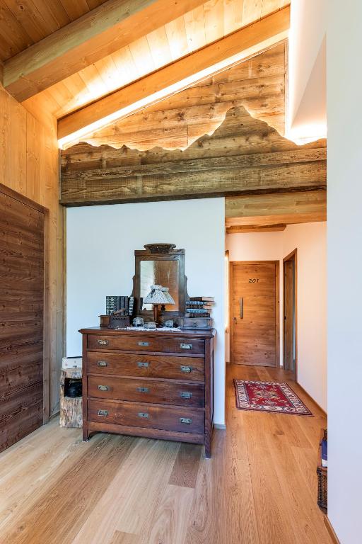 pokój z komodą w pokoju z drewnianym sufitem w obiekcie Locanda "Al Terrazzo" w mieście Erbezzo
