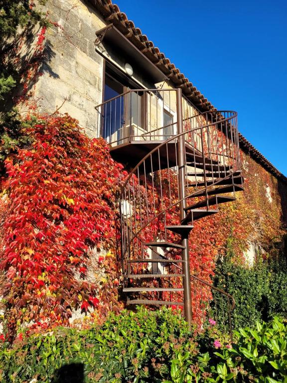 ein Gebäude mit einer Treppe, die mit roten Blumen verziert ist in der Unterkunft Appartement spacieux à Arles avec piscine et jardin partagé in Arles