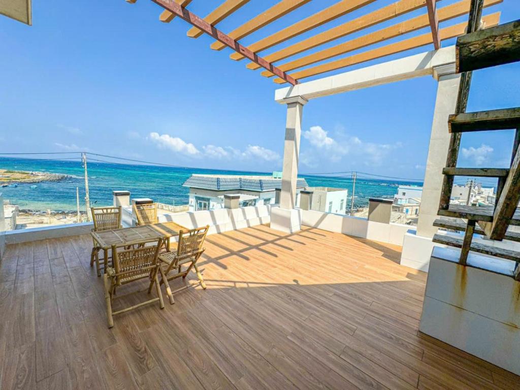 una terrazza con tavolo, sedie e vista sull'oceano di HOMESTAY PHÚC LŨY a Cu Lao Thu