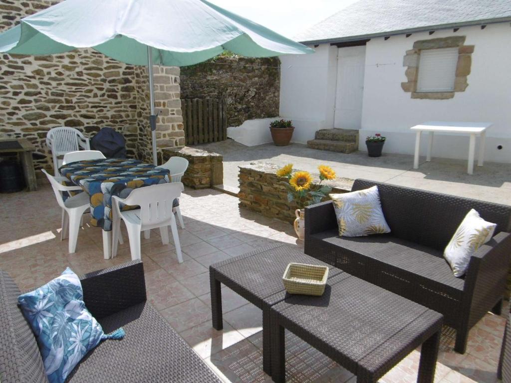 une terrasse avec un canapé, une table et un parasol dans l'établissement Maison 4 pièces 6 personnes proche de la mer - HEOL, à Sarzeau