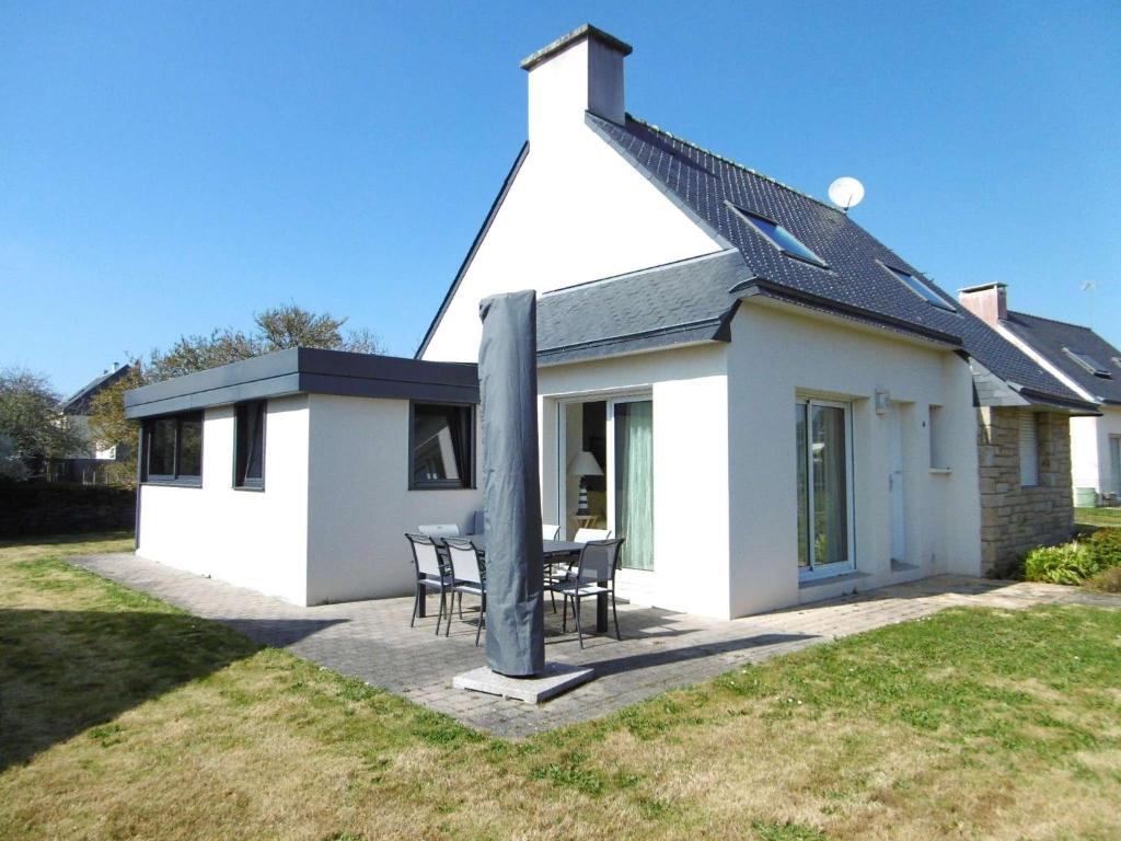 une maison blanche avec une table et des chaises dans l'établissement Maison 5 pièces 8 personnes avec jardin clos à 700 m de la plage - LOAVEN, à Sarzeau