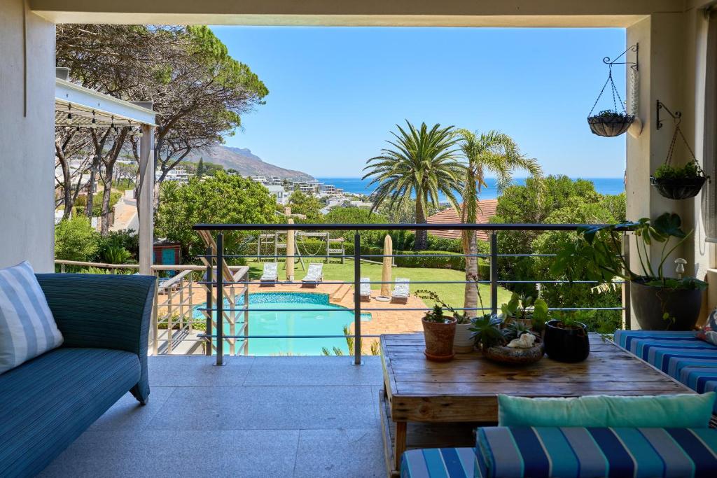a patio with a view of the pool and the ocean at 42 On Strathmore in Cape Town