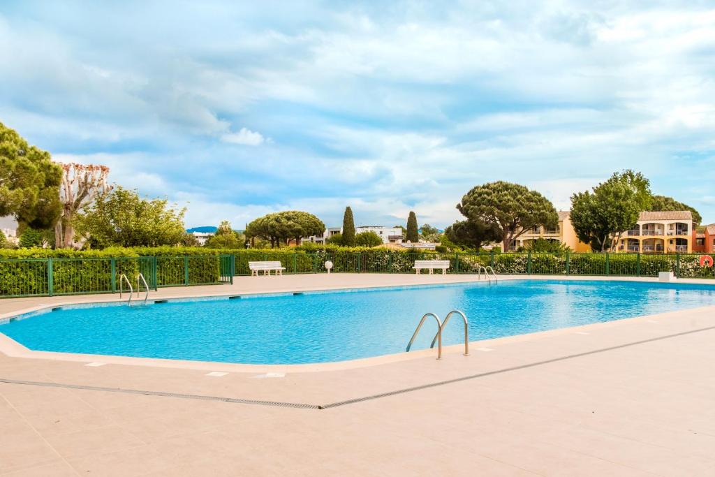 - une piscine dans une villa avec des arbres dans l'établissement Grand studio Les Masters, à Mandelieu-la-Napoule