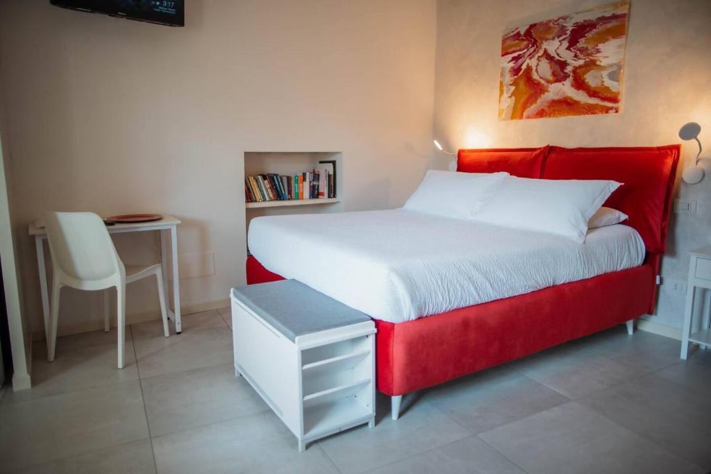 a bedroom with a large bed with a red headboard at Tra Lago Maggiore e lago d'Orta Appartamento FUOCO in Colazza