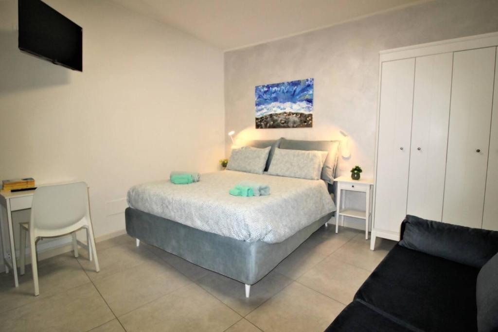 a bedroom with a bed and a table with a chair at Tra Lago Maggiore e lago d'Orta Appartamento ACQUA in Colazza