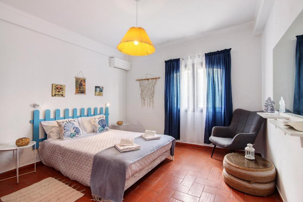 a bedroom with a bed and a chair at Casa Amarela in Tavira