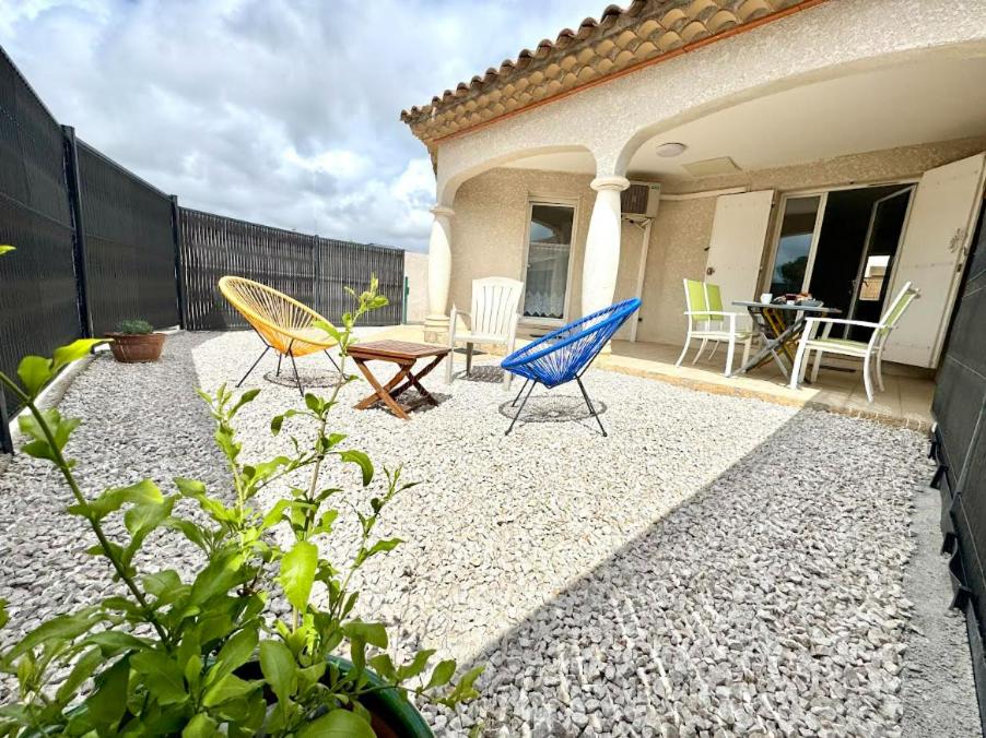 d'une terrasse avec des chaises, une table et des chaises. dans l'établissement T3 en 3 étoiles de plain-pied, climatisé, terrasse, jardinet et parking, très calme, à Pomérols
