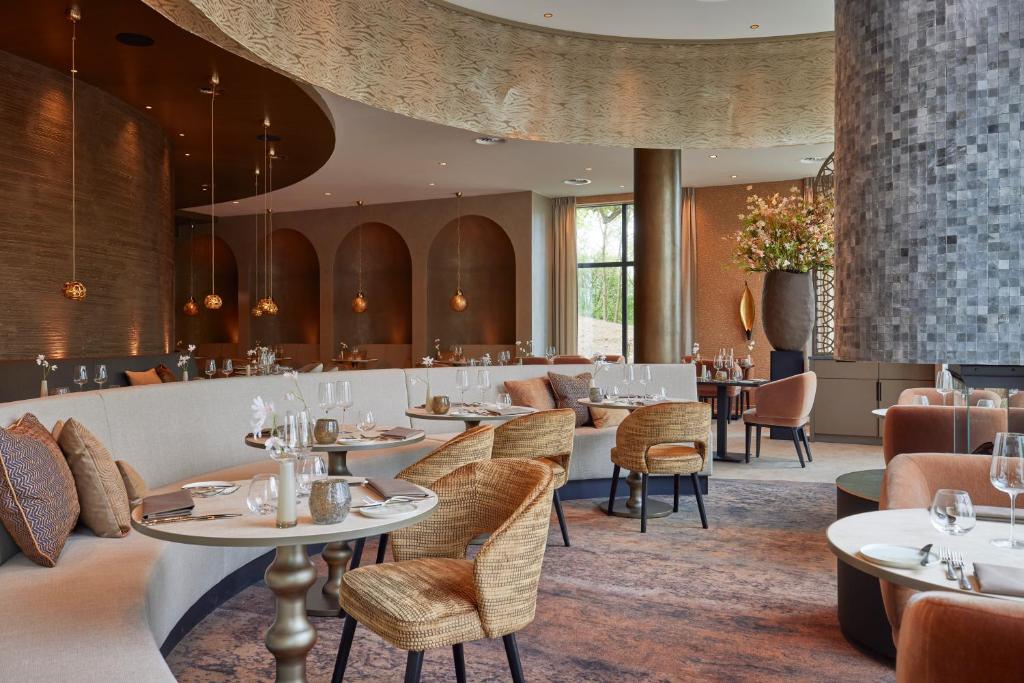 a restaurant with tables and chairs in a room at Hotel Thermen Berendonck in Nijmegen