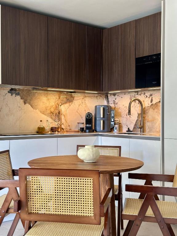 une cuisine avec une table et des chaises en bois dans l'établissement Escapade cannoise, à Cannes