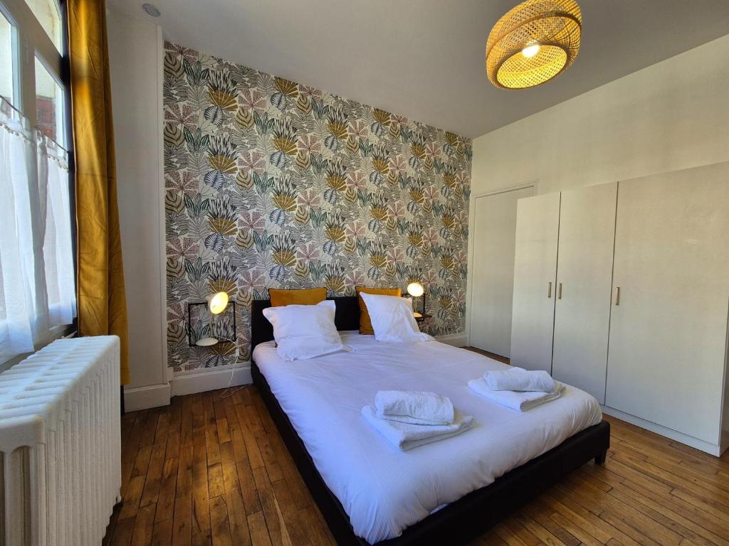 une chambre avec un grand lit avec des serviettes dessus dans l'établissement Les Loges Du Beffroi - La Cloche Dorée, à Arras