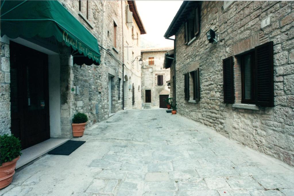 an empty street in an alley with stone buildings at Hotel Tre Ceri in Gubbio