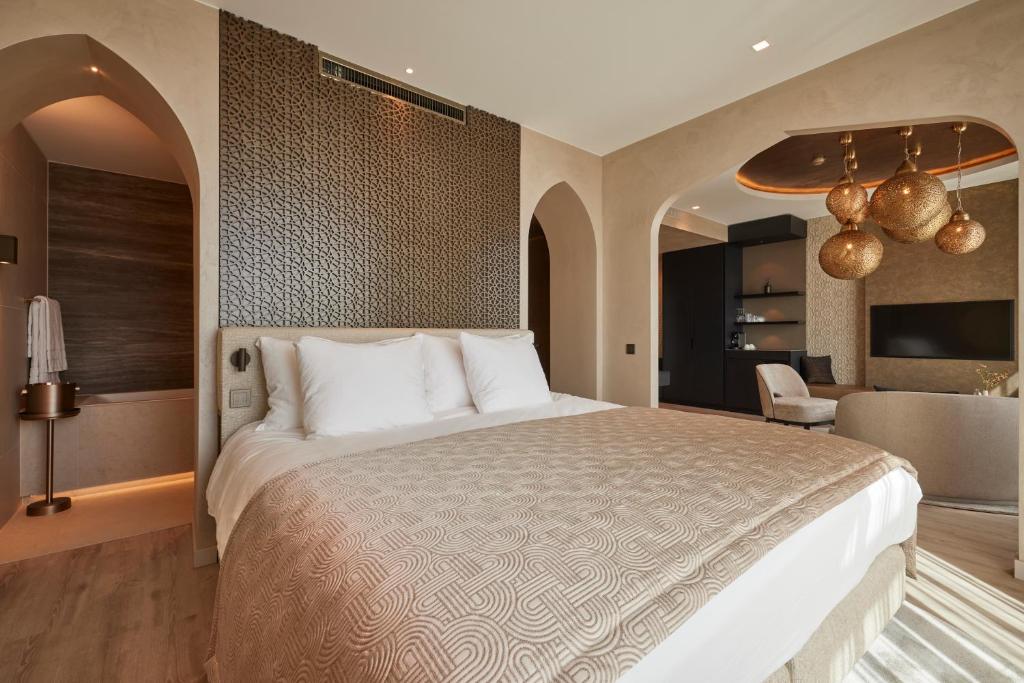 a bedroom with a large bed and a living room at Hotel Thermen Berendonck in Nijmegen