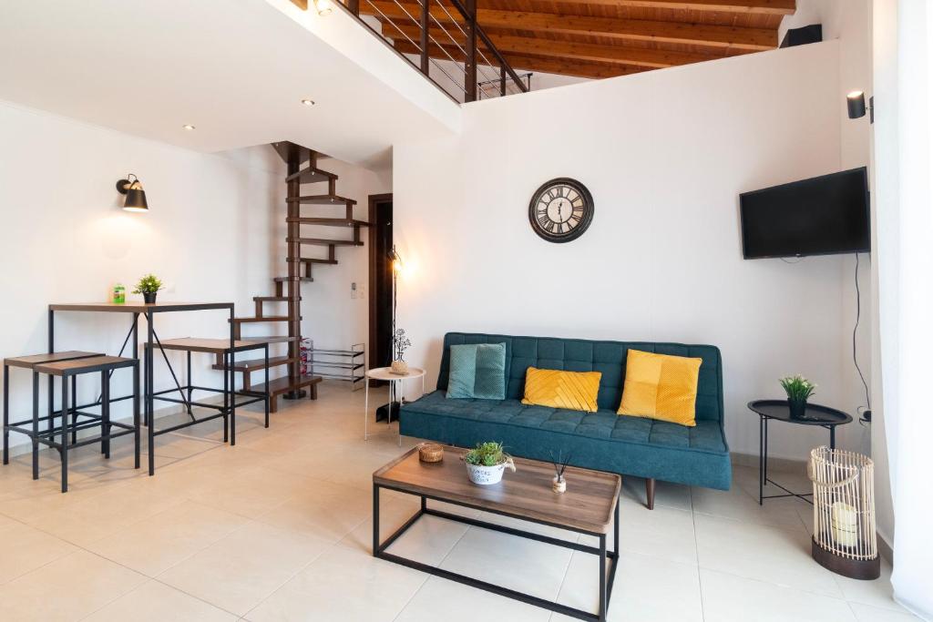 a living room with a blue couch and a table at Chris Luxury Loft in Kallithea Halkidikis