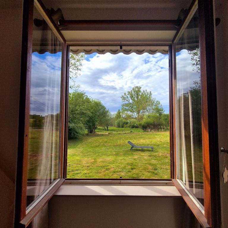 une fenêtre avec vue sur un banc dans un champ dans l'établissement La Planchotte, à Peigney