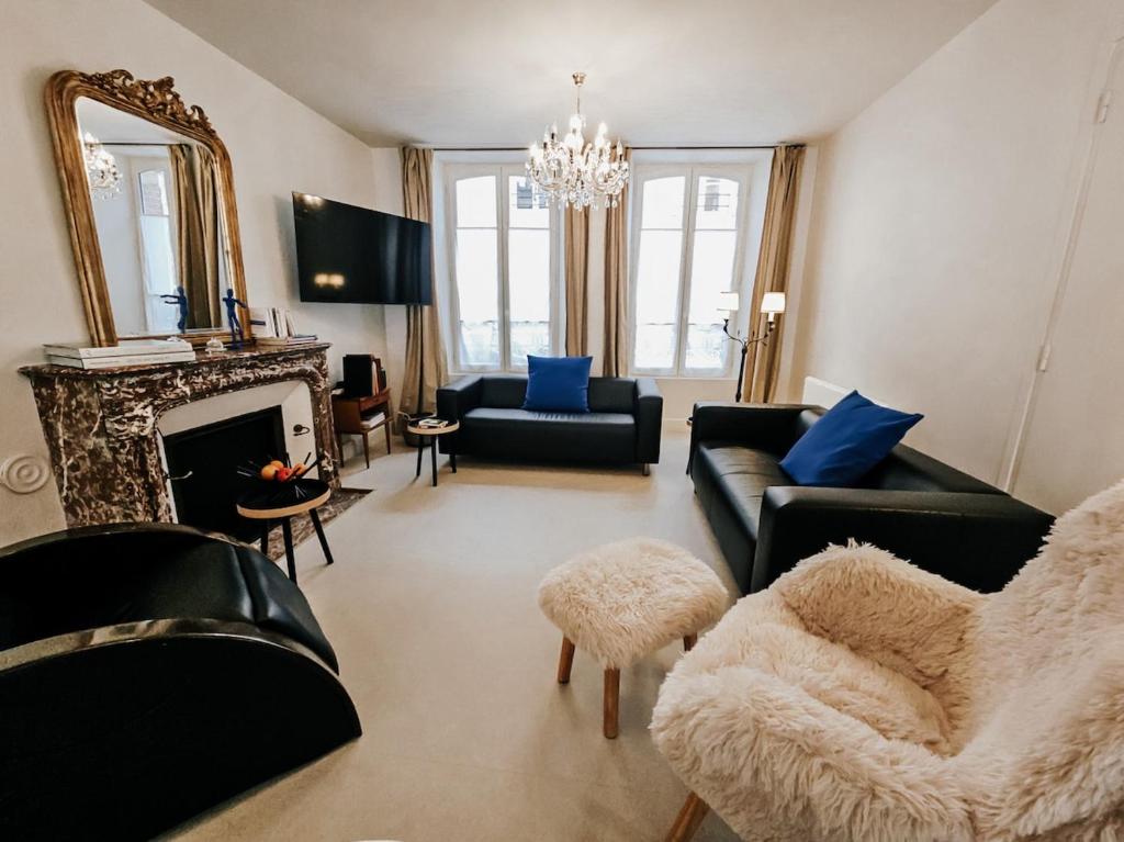 a living room with black furniture and a fireplace at Les Tanins d 'Ay in Ay