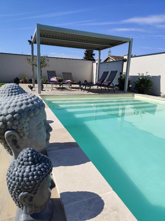 une statue à côté d'une piscine dans l'établissement La Villa d'A-Mours, à Mours-Saint-EusÃ¨be