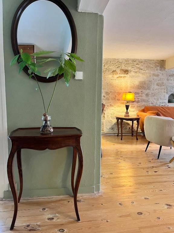 - un salon avec une table et un miroir dans l'établissement Gite du Clocher de la Cathédral charmant duplex, à Périgueux