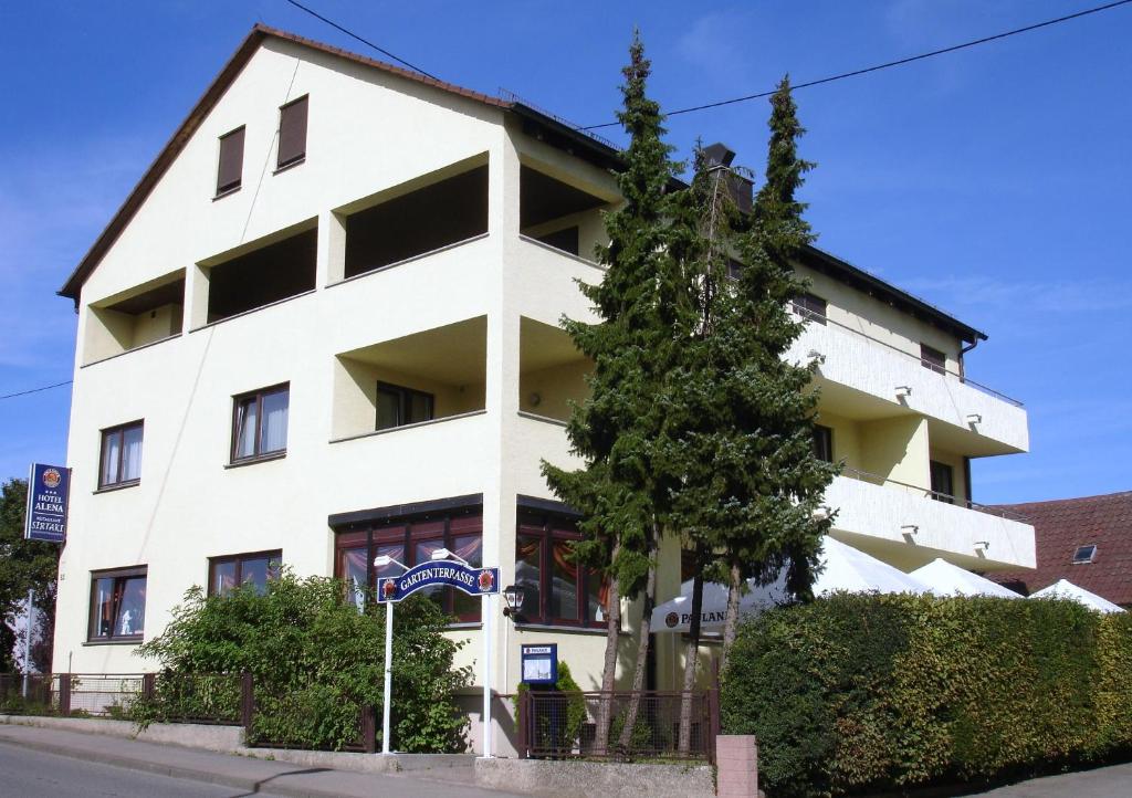 ein weißes Gebäude mit einem Baum davor in der Unterkunft Hotel Alena - Kontaktlos Check-In in Filderstadt