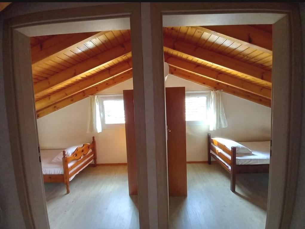 a room with two beds and two windows at 3-Bedroom House with Loft in Corfu by ΜΡS in Agios Georgios