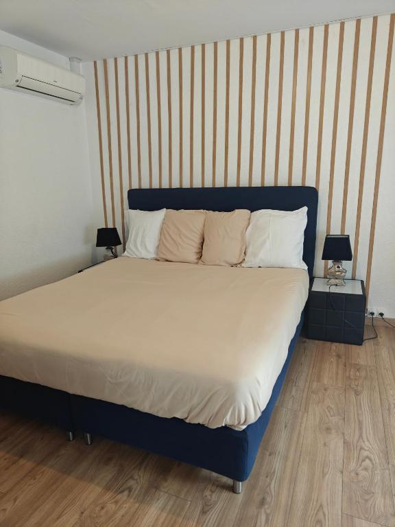 Ce lit se trouve dans un dortoir doté de 2 lampes sur les tables. dans l'établissement Chambre climatisée cosy Auberge du Manala Hôtel 24-24, à Saint-Louis