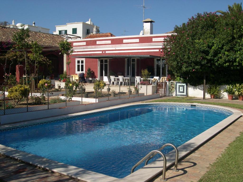 a swimming pool in front of a house at Quinta dos Reis in Alcantarilha