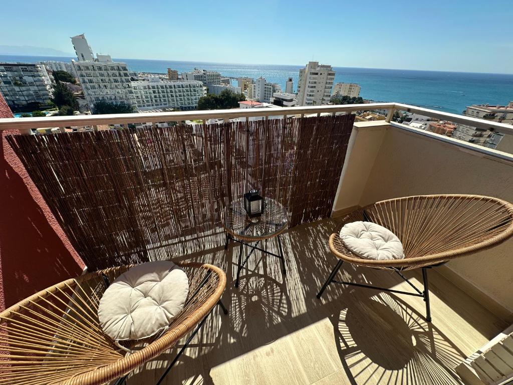 a balcony with two chairs and a view of the ocean at Apartamento JÚPITER Vistas in Benalmádena