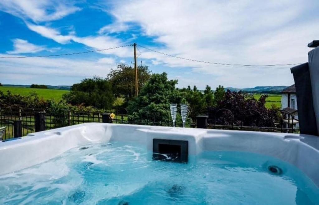 Una bañera de hidromasaje con vista a un campo. en Thomas Carlyle Cottage, en Thornhill