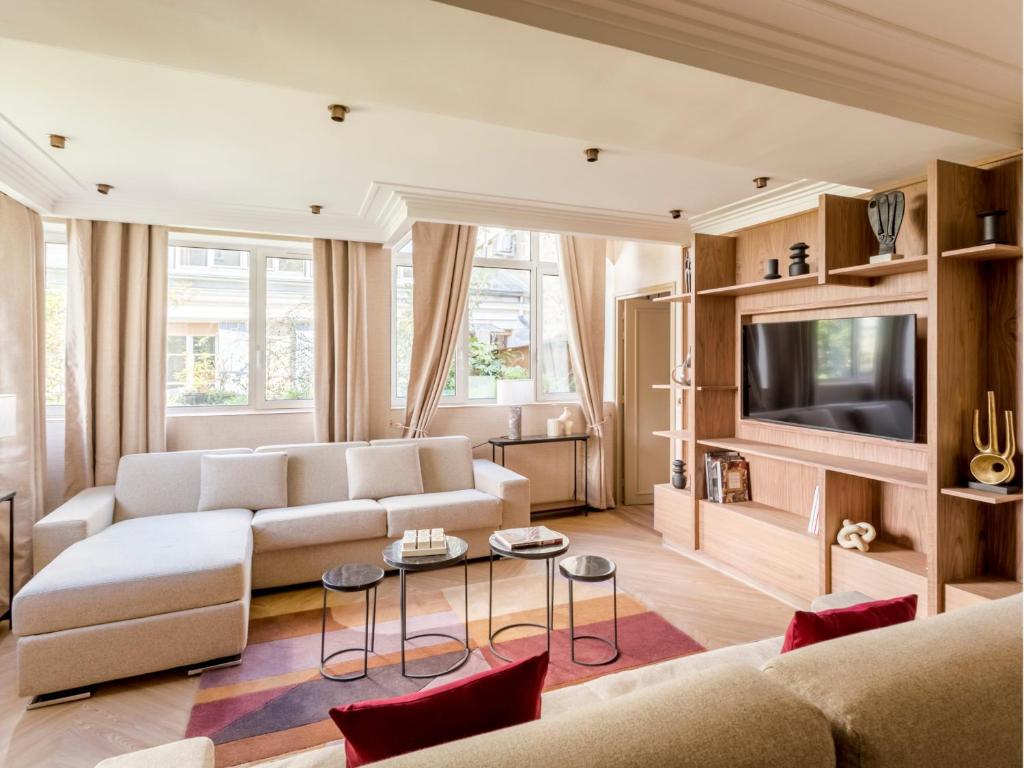 un salon avec un canapé et une télévision dans l'établissement Merveil - Signature Suite - Tour Eiffel - Viala IV, à Paris