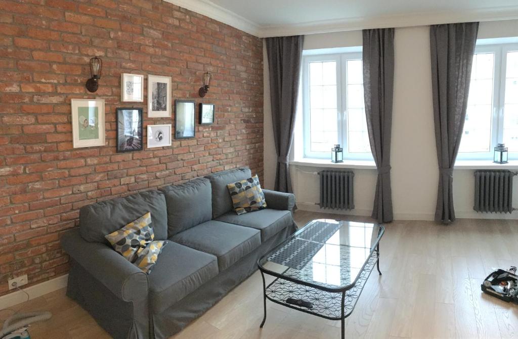 een woonkamer met een bank en een bakstenen muur bij APARTAMENTY DŁUGI TARG in Gdańsk