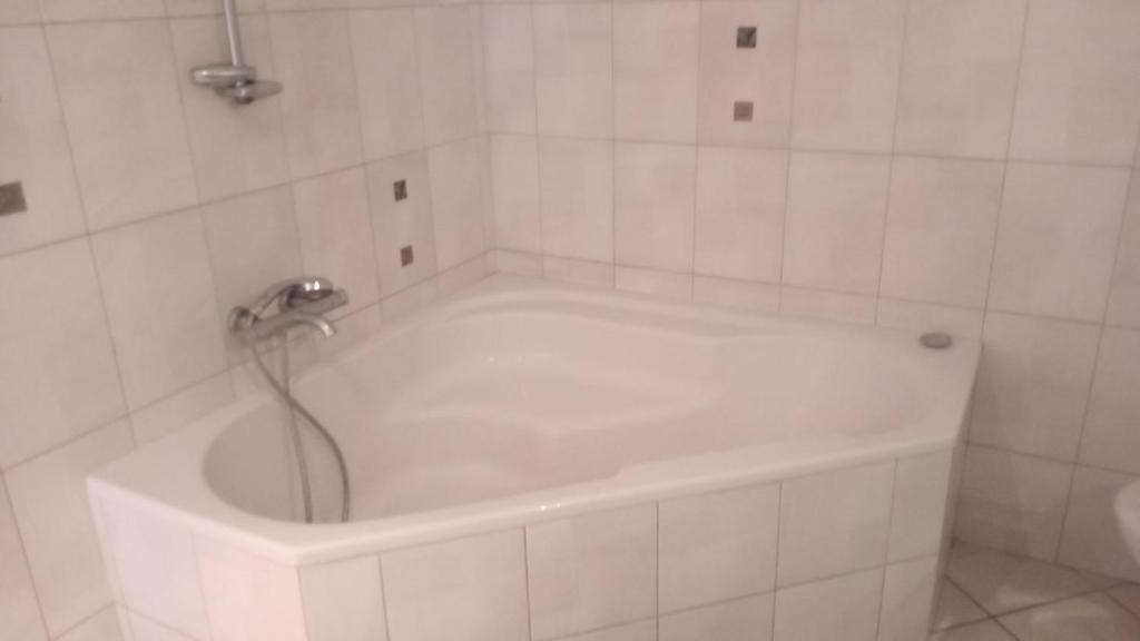 La salle de bains est pourvue d'une baignoire blanche avec un robinet. dans l'établissement Corp de ferme, à Villy-Bocage