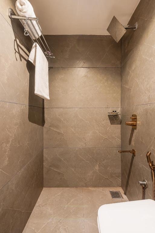 ムンバイにあるHotel Silver Parkのバスルーム(シャワー、トイレ、洗面台付)