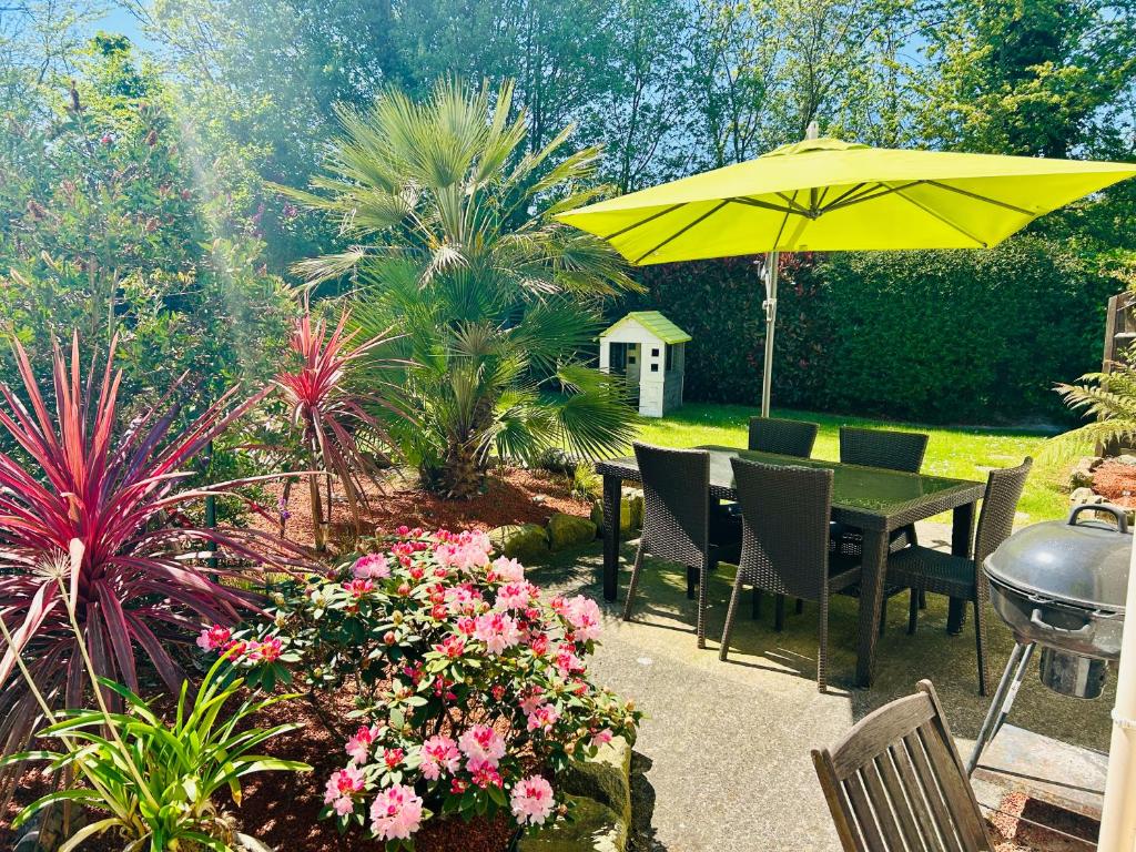 d'une terrasse avec une table et un parasol jaune. dans l'établissement Maison de vacances Bretagne, à Tréveneuc