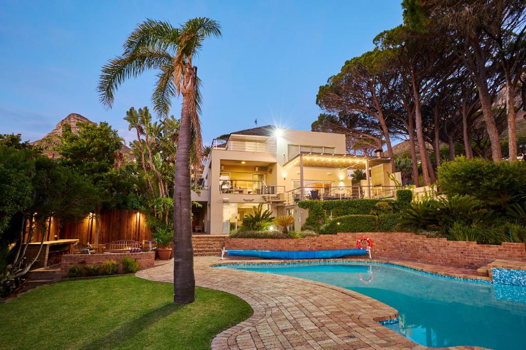 a house with a swimming pool and a palm tree at 42 On Strathmore in Cape Town