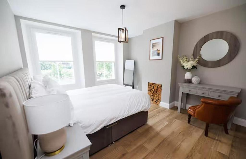 Un dormitorio con una cama, un escritorio y un espejo. en Stylish 3-Bed Apartment in the Heritage Quarter, en Dunfermline