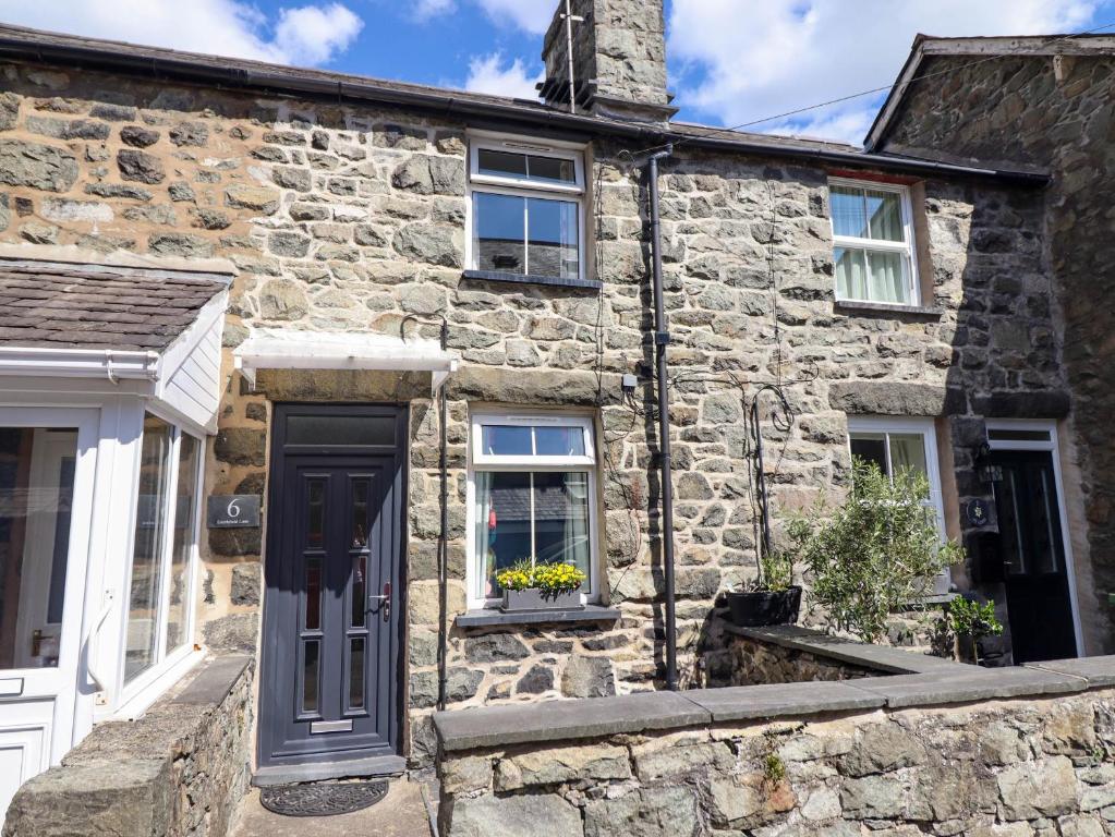 ドルゲラウにある6 Smithfield Laneの黒いドアと窓のある古い石造りの家