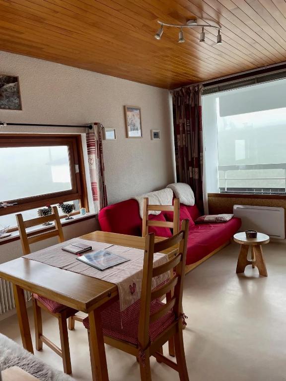 un salon avec une table et un canapé dans l'établissement Appartement cosy à Chamrousse avec vue sur montagne + 34m²., à Chamrousse