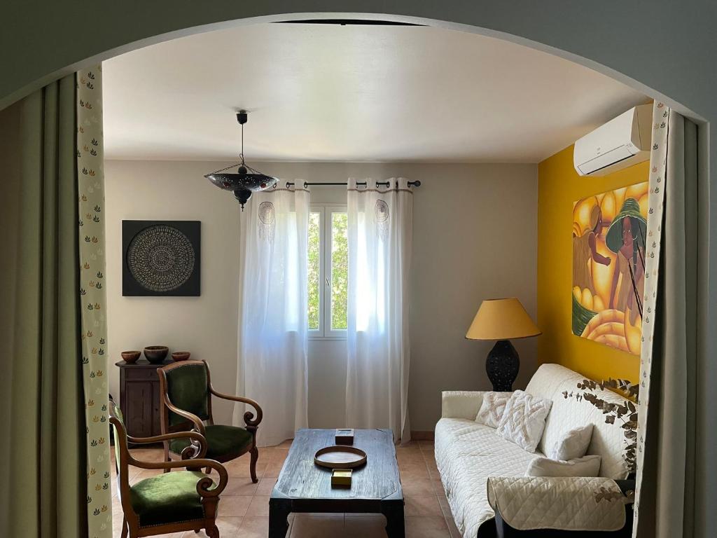 un salon avec un canapé et une table dans l'établissement Les Jardins d'Holi appartement proche Uzès, à Garrigues-et-Sainte-Eulalie