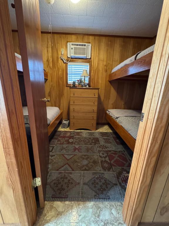 a small room with two bunk beds and a rug at The Miss Ella Houseboat 