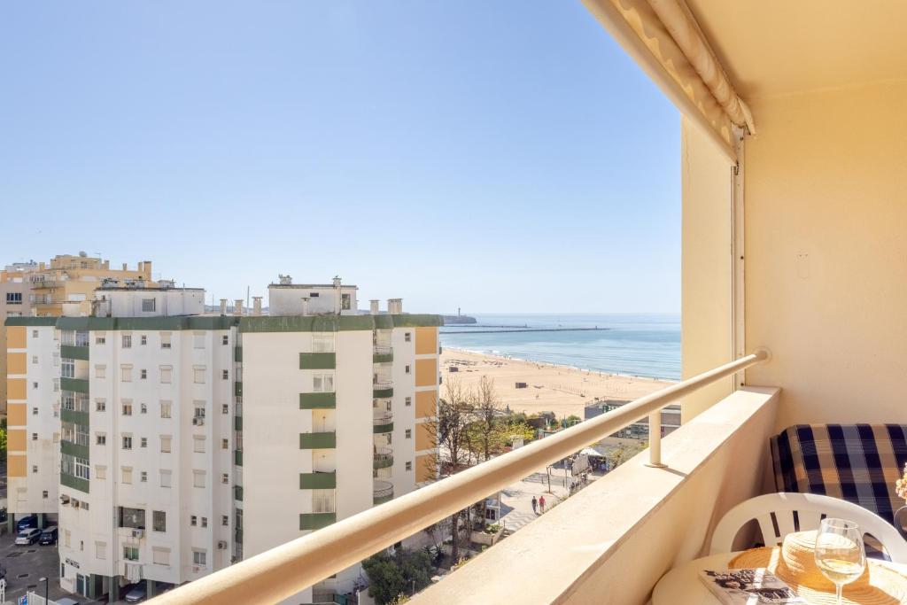 einen Balkon mit Blick auf den Strand und die Gebäude in der Unterkunft Holiday Praia da Rocha in Strand Praia da Rocha