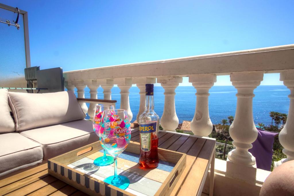 une table avec deux bouteilles et un verre de vin sur un balcon dans l'établissement Appartement vue mer plage à pied, à Saint-Raphaël