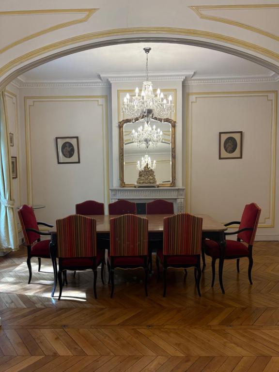 une salle à manger avec une table, des chaises et un lustre dans l'établissement 3 bedroom Eiffel Tower Apartment, à Paris