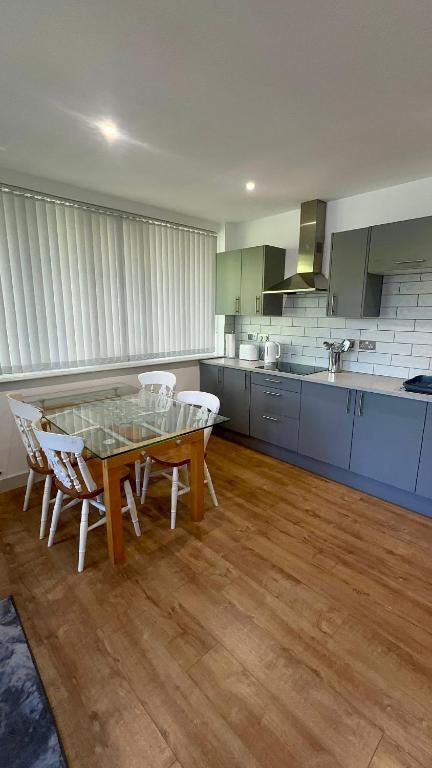 a kitchen with a table and chairs in a room at Spacious 2 Bedroom Flat City Centre in Cannock