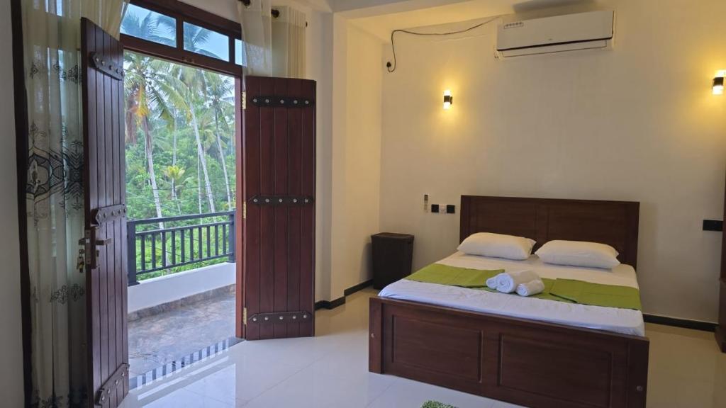 a bedroom with a bed and a large window at White Breeze Villa Ahangama in Ahangama